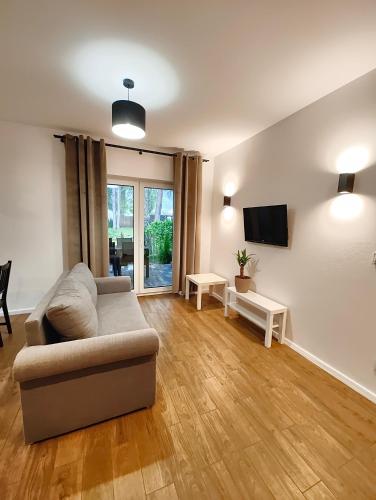 a living room with a couch and a tv at Apartament Szum in Susiec