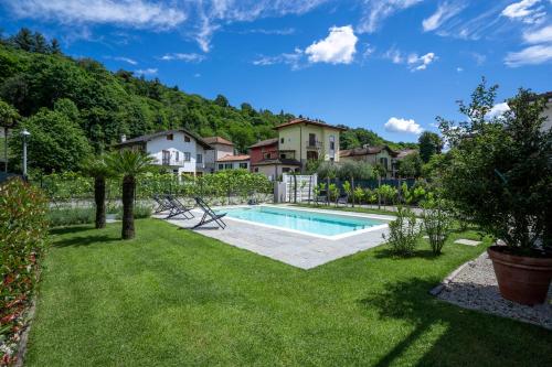 a yard with a swimming pool and houses at Le Casette di Orta Apartments in Orta San Giulio