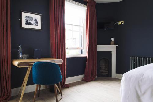 a bedroom with a desk and a window and a bed at The Porterhouse grill & rooms in Oxford