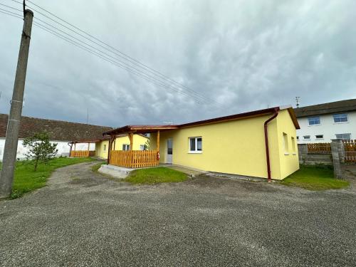 a yellow building with a pole in front of it at Pension u Vlčků in Hracholusky