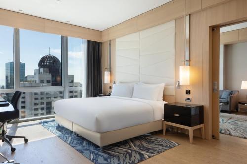a bedroom with a large white bed and a desk at Wyndham Grand Istanbul Levent Hotel & Conference Center in Istanbul