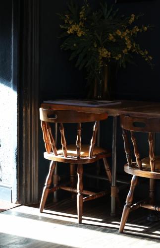 a wooden table and a chair with a vase of flowers at The Porterhouse grill & rooms in Oxford