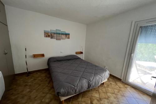 une chambre avec un lit dans une pièce avec une fenêtre dans l'établissement sympathique T2 dans un super village vacance Hawaï 5, à Canet