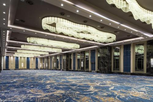 an empty ballroom with chandeliers and a large room with a blue floor at Wyndham Grand Istanbul Levent Hotel & Conference Center in Istanbul