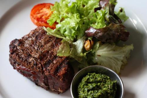 a plate with a steak and a salad and a sauce at The Porterhouse grill & rooms in Oxford
