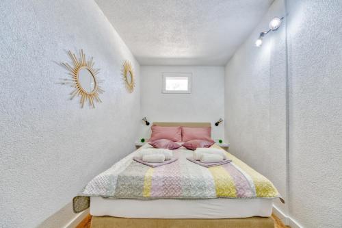 a small bedroom with a bed and a mirror at Villa Grammy in Bol