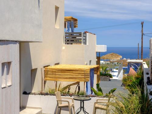 a patio with a table and chairs and a building at Nalu Suites in Fira