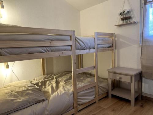 une chambre avec deux lits superposés et une table dans l'établissement Mazet provençal, à Eyguières