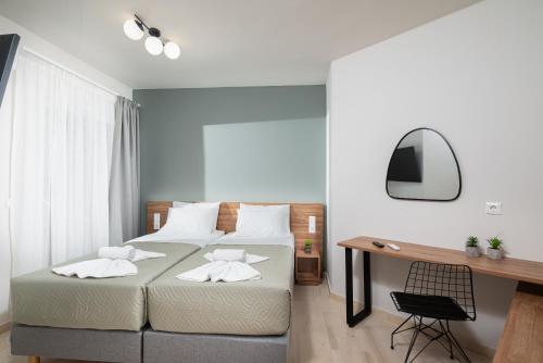 a bedroom with two beds and a desk at Makas Beach Suites Seafront Sea View in Hersonissos in Hersonissos