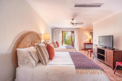 a bedroom with two beds and a television in it at Seaside Bliss with pool and spectacular view in Las Minas