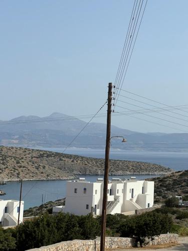 a white building on a hill with a body of water at Alexandra’s studios in Iraklia
