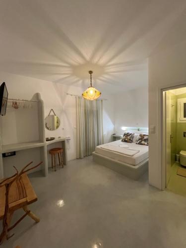 a large white bedroom with a bed and a table at Alexandra’s studios in Iraklia
