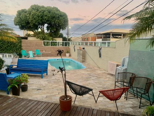 un patio con una piscina con sillas y un sofá en Casa Suakasa Temporada Praia de Itaparica, en Vila Velha