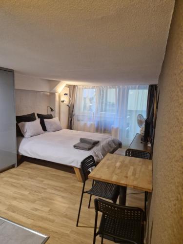 a bedroom with a bed and a table and chairs at Studio SIEVA in Lausanne