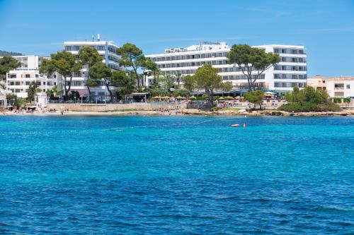 a large body of water with buildings in the background at Leonardo Royal Hotel Ibiza Santa Eulalia in Es Cana