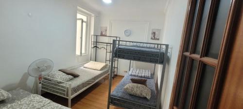 a room with two bunk beds and a fan at Garden Guest House in Lisbon