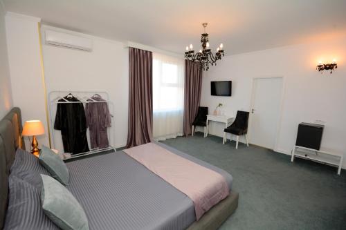 a bedroom with a bed and a desk and a television at Hotel Andre´s in Craiova