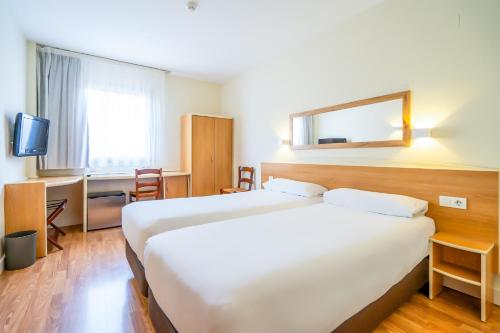 Habitación de hotel con 2 camas y escritorio en Hotel YIT Ciudad de Elche, en Elche