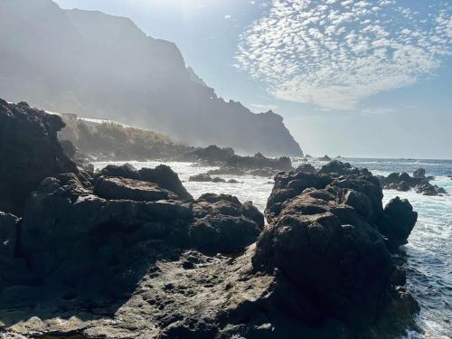 a group of rocks on a beach with the ocean at Finca mit Meerblick und Jacuzzi in Las Cruces