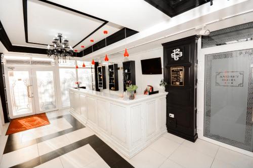 a large room with a lobby with white walls and a chandelier at Hotel Andre´s in Craiova