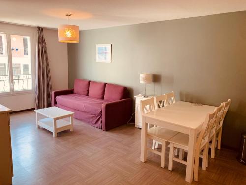 uma sala de estar com um sofá roxo e uma mesa em Terres de France - Résidence Côté Provence em Gréoux-les-Bains