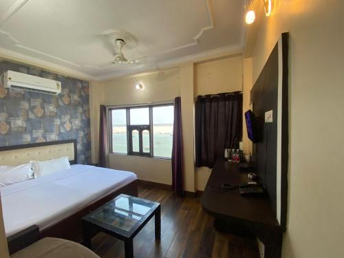 a small room with a bed and a tv at Hotel Sita Place On Heritage Ghats Of Benaras in Varanasi