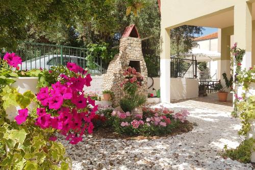 a garden with pink flowers in a yard at Moloha in Skala Kallirakhis