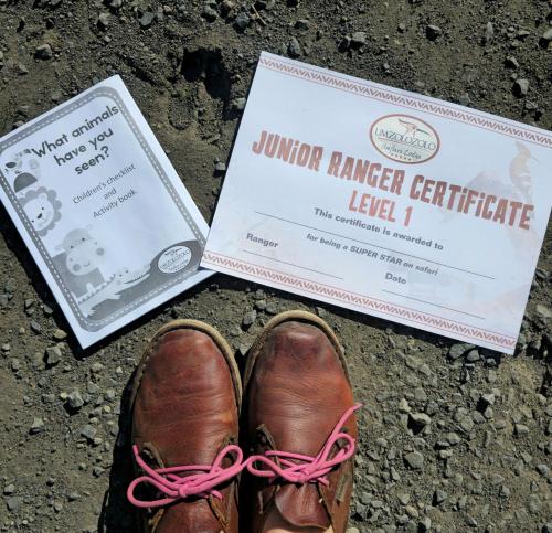 a pair of shoes sitting on the ground with a voter certificate at Umzolozolo Private Safari Lodge & Spa in Nambiti Private Game Reserve