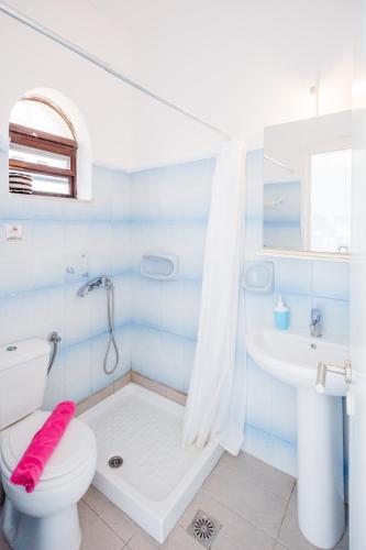 a blue and white bathroom with a toilet and a sink at Babis Studios in Kalamaki