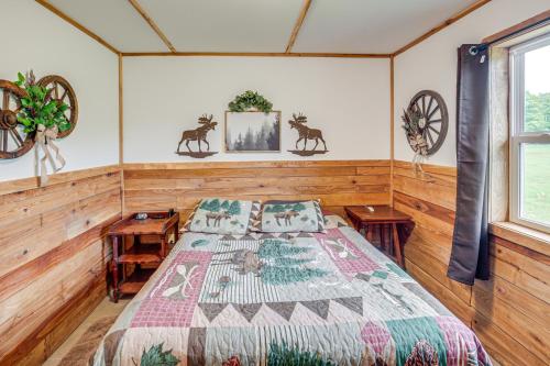 um quarto com uma cama num quarto com paredes de madeira em Toivola Home with Fire Pit 8 Mi to Lake Superior! em Toivola