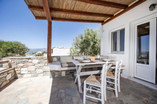 a patio with a table and chairs and a couch at Thea Suites Naxos in Agios Prokopios
