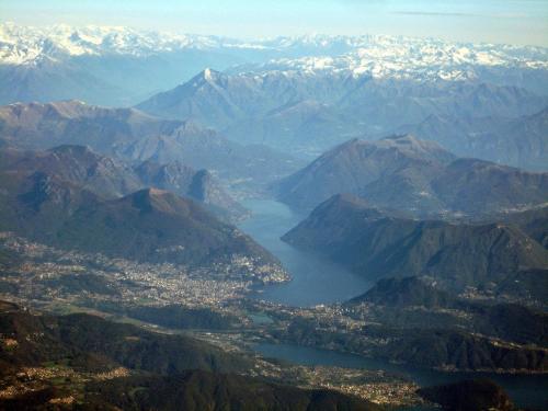 a view of a mountain range with a city and a lake at Modern apartament in Porlezza
