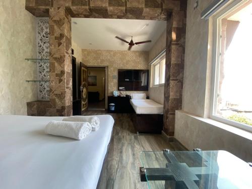 a bedroom with a bed and a bathroom with a sink at Hotel Sita Place On Heritage Ghats Of Benaras in Varanasi
