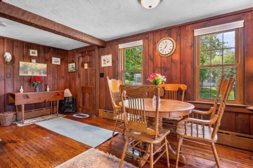 a dining room with a table and chairs and a clock at 39 Jefferson Shores Bourne - Vacation Bliss on Buttermilk Bay in Buzzards Bay