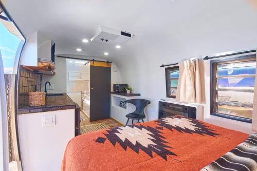a bedroom with an orange blanket on a bed in a caravan at Acres Landing in Desert Hot Springs