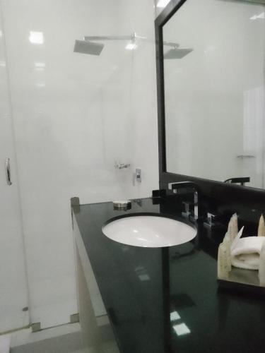 a bathroom with a sink and a mirror at Suites del Bosque Hotel in Lima
