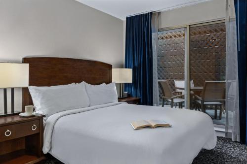 a hotel room with a bed with a book on it at The Suites at Fisherman's Wharf in San Francisco