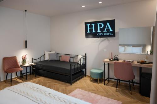 a bedroom with a bed and a desk with chairs at IRA - ΗΡΑ Hotel in Kalamata