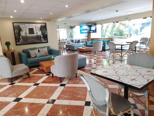 a lobby with couches and tables and chairs at Suites del Bosque Hotel in Lima