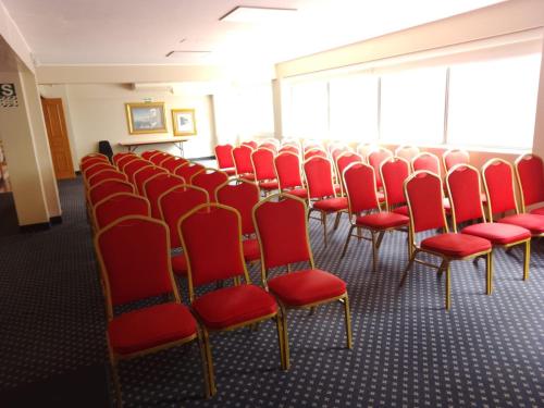 a row of chairs with red seats in a room at Suites del Bosque Hotel in Lima