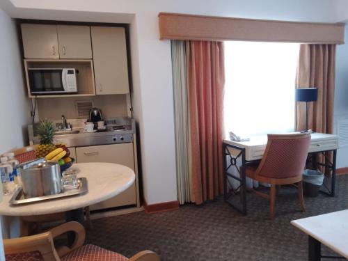 a hotel room with a kitchen and a table with a table at Suites del Bosque Hotel in Lima
