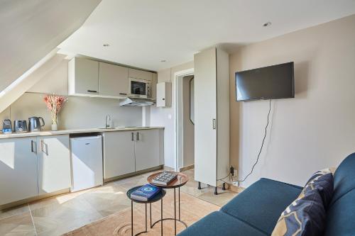 un salon avec un canapé bleu et une cuisine dans l'établissement Charming Studio Center of Paris Le Marais by Studio Prestige, à Paris