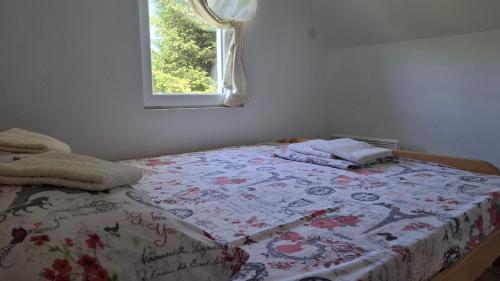 a bed with a quilt on it in a bedroom at Vila Holiday - Golija in Novi Pazar