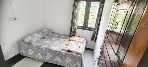 a room with a couch and a window and a door at Johns Villa in Sultan Bathery