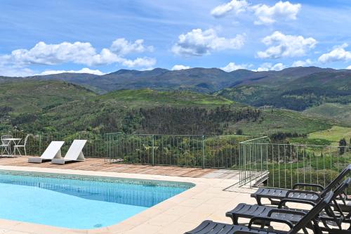 a swimming pool with chairs and a view of mountains at Casas das Olas in Arcos de Valdevez