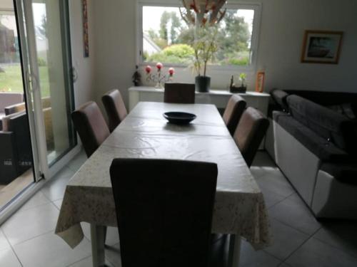 - une salle à manger avec une table, des chaises, une table et des chaises dans l'établissement Maison proche de la mer, à Plestin-les-Grèves