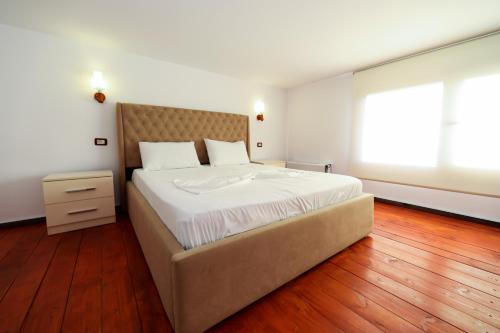 a bedroom with a large bed and a large window at Vila Dena in Vlorë