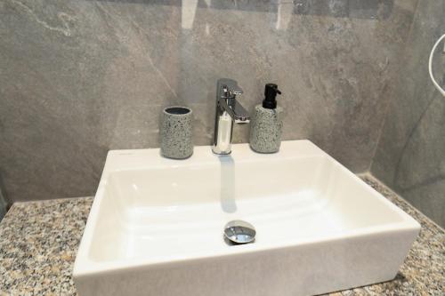a white sink with a soap dispenser on it at Vila Dena in Vlorë