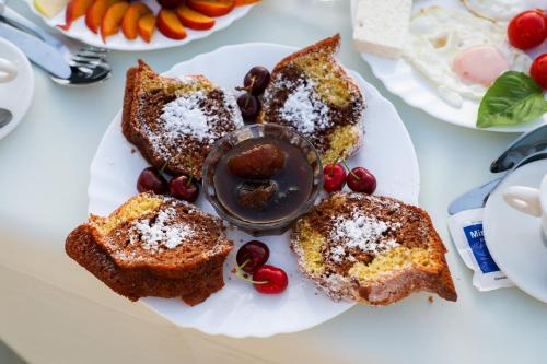 a plate of food with bread and fruit on a table at Vila Dena in Vlorë