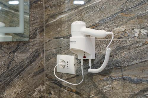 a white electrical outlet on a stone wall at Vila Dena in Vlorë